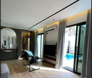 ein Wohnzimmer mit einem TV und einem großen Fenster in der Unterkunft شاليه سدرة فاطمه in Banī Ma‘n