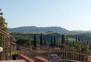 a balcony with a fence and a view of a mountain at Appartamento Il Glicine in Montalcino