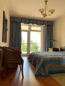 a bedroom with a bed and a chair and a window at Апартаменты Карвен Иссык-Куль Karven Issyk-Kul in Bulan Sogottuu