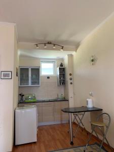 a kitchen with a table and a refrigerator in a room at Апартаменты Карвен Иссык-Куль Karven Issyk-Kul in Bulan Sogottuu +3 photos