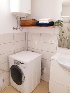 a white washing machine in a bathroom with a sink at Apartment Ognissanti 1 - free parking in Koper