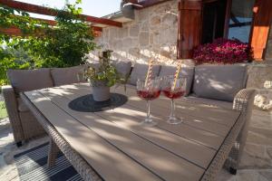 una mesa con dos copas de vino en un patio en Villa Silente, en Ljubuški