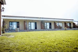een gebouw met een grasveld ervoor bij Plot 19 in Ghanzi