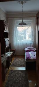 een kamer met een raam, een bed en een tafel bij Vida vendégház in Hajdúszoboszló
