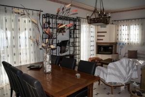 ein Esstisch mit einer Vase mit Blumen darauf in der Unterkunft Villa marina " G " in Argassi