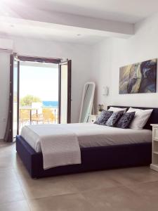 a bedroom with a large bed and a large window at All Blue Suites in Ambelas