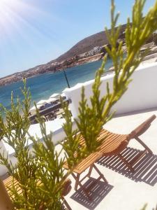 een houten stoel op een balkon naast de oceaan bij All Blue Suites in Ambelas