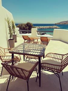 een patio met een tafel en stoelen en het water bij All Blue Suites in Ambelas