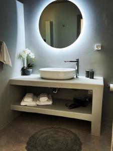 een badkamer met een witte wastafel en een spiegel bij All Blue Suites in Ambelas