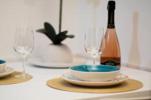 a table with two wine glasses and a bowl and plate at Meraki House in Alghero