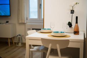 a dining room table with two plates and wine glasses at Meraki House in Alghero