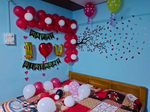 Una cama con globos y un cartel que diga feliz cumpleaños en Gharat Cottage en Alibaug
