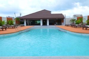 a large swimming pool with chairs and a building at Siam View Hotel and Residence in Pattaya