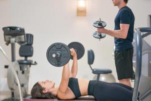 a man and a woman in a gym lifting a weight at Relais Valle Dell'Idro - Rooftop & Sea View, Otranto in Otranto