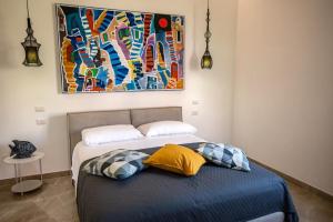 Villa Barone في بروسيدا: سرير مع وسادتين ولوحة على الحائط