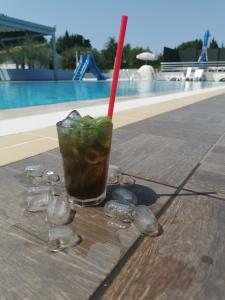 a drink sitting on a table next to a pool at Resort Zatišje in Savudrija