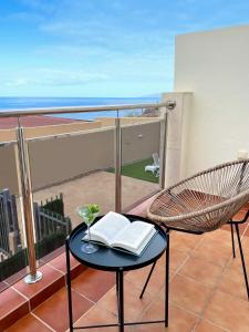 krzesło i stół z książką na balkonie w obiekcie Luxury Villa Teno with private heated pool w Adeje