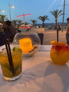 una mesa con dos bebidas y una naranja en ella en Taylors Camposol Apartment, en Mazarrón