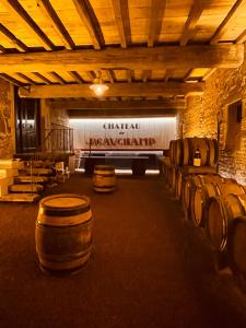 une cave avec des fûts de vin dans un bâtiment dans l'établissement Château de Beauchamp- La chapelle de Guinchay, à La Chapelle-de-Guinchay