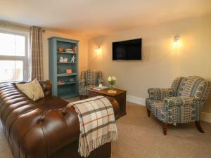 a living room with a leather couch and a chair at Audleby in Market Rasen