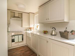 a white kitchen with white cabinets and a sink at Audleby in Market Rasen