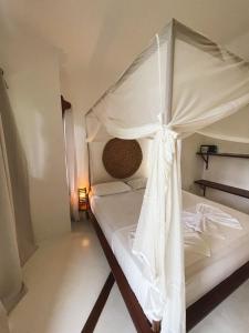 a bedroom with a white bed with a canopy at Pousada Pais Tropical in Icaraí