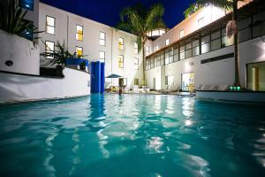a swimming pool in front of a hotel at night at Hotel do Mar in Povoação