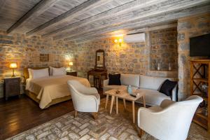 a bedroom with a bed and a couch and chairs at Guesthouse Laoula in Gerolimenas