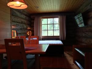 ein Esszimmer mit einem Tisch und einem Fenster in der Unterkunft Kelo Seasons Spring in Luosto