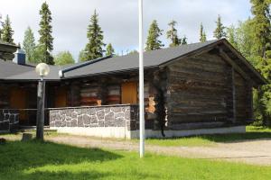 a log cabin with a pole in front of it at Kelo Seasons Spring in Luosto