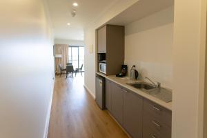 a kitchen with a sink and a microwave at Lady Bay Hotel in Normanville