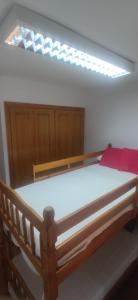 ein Schlafzimmer mit einem Holzbett mit einer Lampe darüber in der Unterkunft Apartamento San Agustín Playa in Villajoyosa