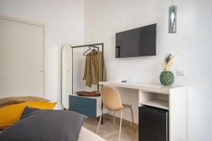 Villa Barone في بروسيدا: غرفة نوم مع مكتب وسرير مع تلفزيون