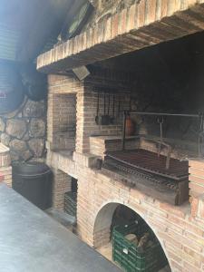 un horno de ladrillo al aire libre con una pared de piedra en Casa Rural LOS TINES, en Bustarviejo