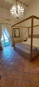- une chambre avec un grand lit et un lustre dans l'établissement Casa Raiola Ercolano Luxury Rooms & Spa, à Ercolano