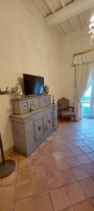 a living room with a tv on top of a cabinet at Casa Raiola Ercolano Luxury Rooms & Spa in Ercolano
