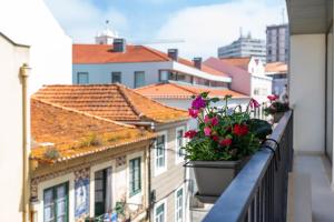 a balcony with flower pots on a building at Ria Sal apartments in Aveiro