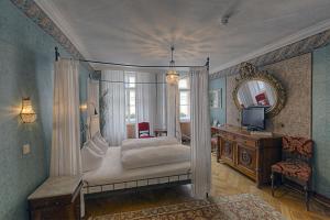 Dormitorio con cama con dosel, escritorio y TV en Hotel Orphée - Kleines Haus, en Regensburg