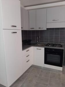 a white kitchen with white cabinets and a stove at La Porta sul Mare in Pizzo