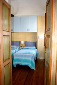 una camera con due letti con lenzuola blu e una porta di Ai Cappuccini a Racconigi