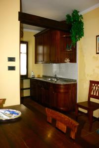 eine Küche mit Holzschränken, einem Tisch und einer Bank in der Unterkunft Ai Cappuccini in Racconigi