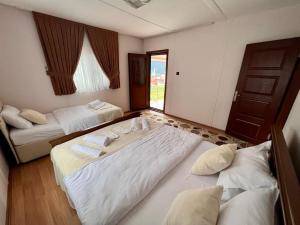 a hotel room with two beds and a door at Kibar Home in Uzungol