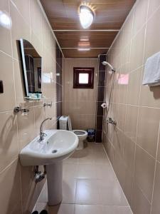 a bathroom with a sink and a toilet at Kibar Home in Uzungol