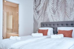 - une chambre avec un grand lit blanc et des oreillers rouges dans l'établissement Mila Apartment Vienna, à Vienne