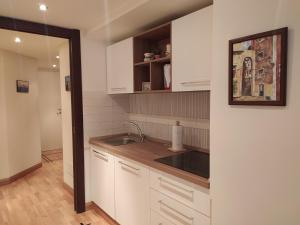 Una cocina con gabinetes blancos y un fregadero. en Edel House Ostia, en Lido di Ostia 24 fotos más