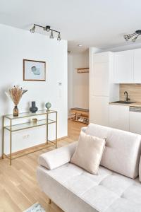 ein Wohnzimmer mit einem weißen Sofa und einer Küche in der Unterkunft Mila Apartment Vienna in Wien