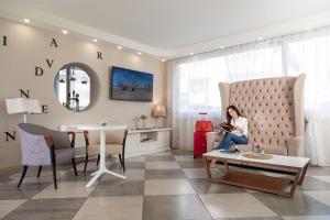 una donna seduta su un divano in soggiorno di Nero D'Avorio Apartments a Rimini