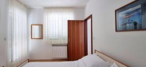 a bedroom with a bed and a door and windows at Old Town Heritage by Mrav in Sukošan