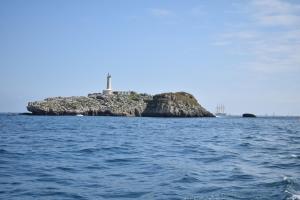 an island in the water with a lighthouse on it at Apartamentos Somo 2 in Somo