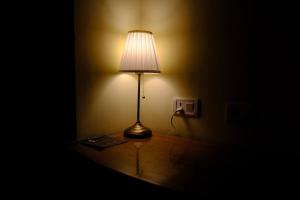 una lampada seduta su un tavolo in una stanza buia di Shantiniketan Mountain Home ad Almora
